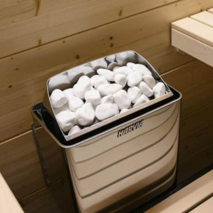 Harvia KIP sauna heater with sauna stone box with white decorative stones inside, mounted on a wooden wall.