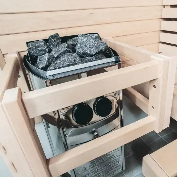 Harvia Vega sauna heater with rocks inside, set against the wooden sauna interior of Finnmark Designs FD-4.