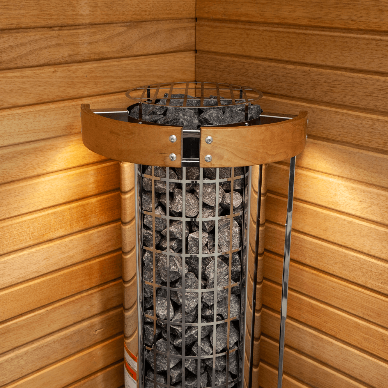 A corner-mounted Harvia Cilindro Half Series Electric Sauna Heater with an exposed sauna stone column cylinder, set against a wooden-paneled corner wall.