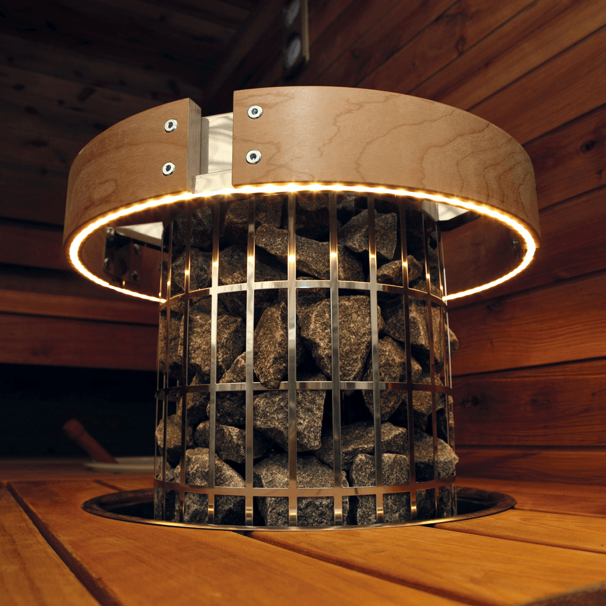 Harvia Cilindro heater integrated through a sauna bench with an embedding flange, with Harvia Cilindro LED safety railing with heat-treated wood detail