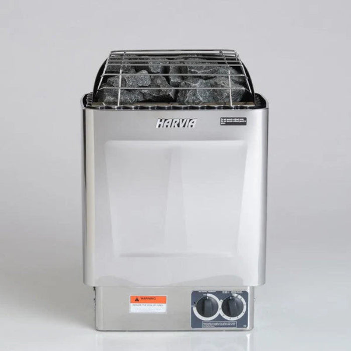 Harvia KIP with built in controls sauna heater with metal basket and stones on a grey background.
