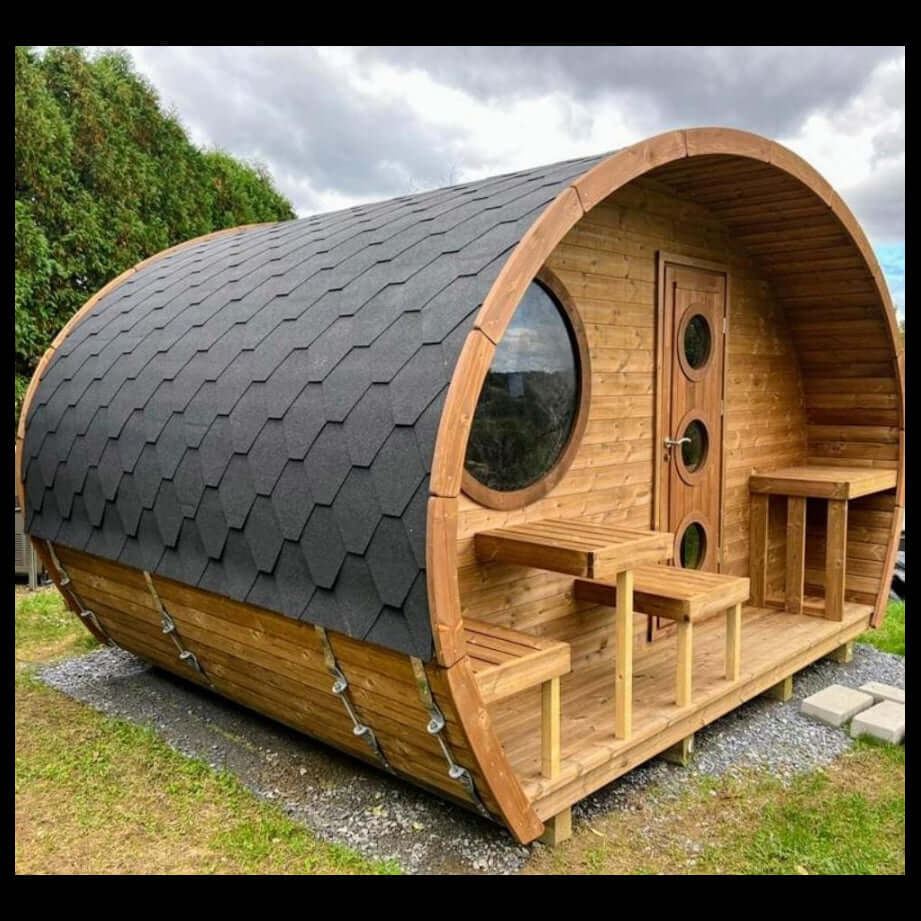 Wooden barrel-shaped G11 sauna by SaunaLife, with a roof on a grassy area