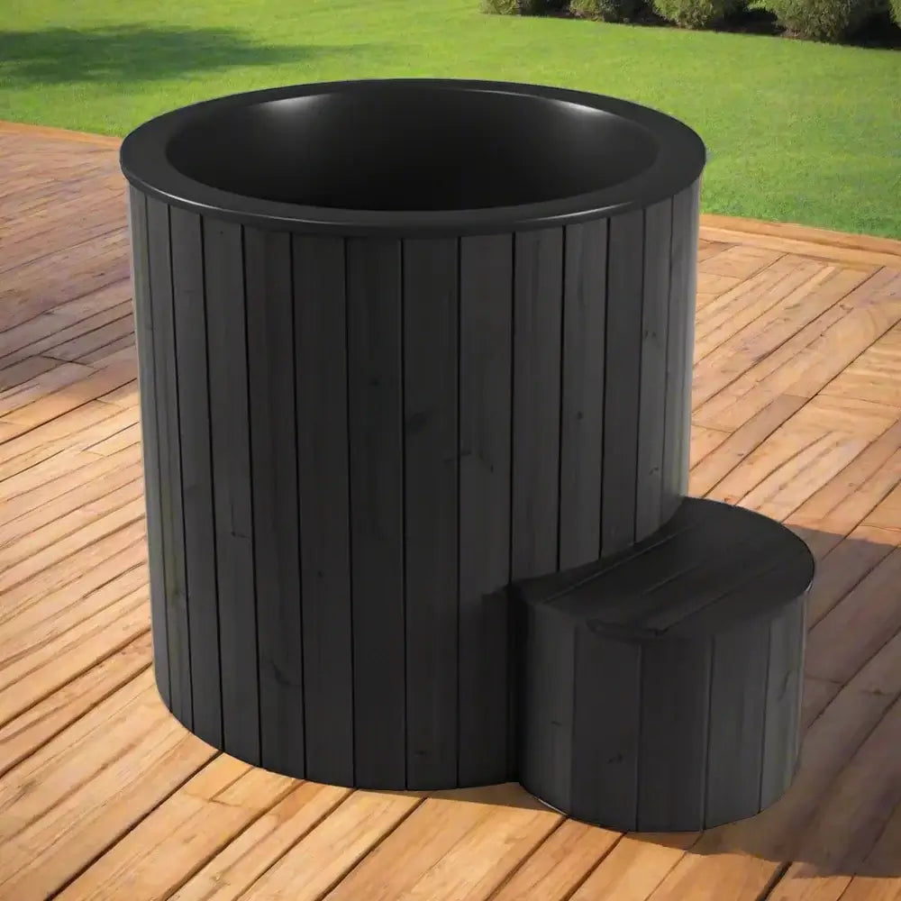 Black wooden S1B plunge tub, by SaunaLife, on a wooden deck with grass in the background