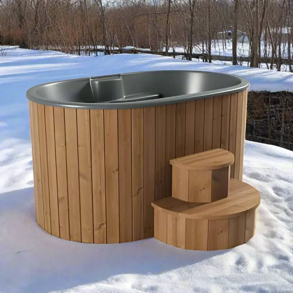 SaunaLife 2-person s2n cold and hot plunge tub made of thermo-pine wood with ergonomic fiberglass interior, featuring a natural wood exterior and matching access stairs, in a snowy outdoor setting