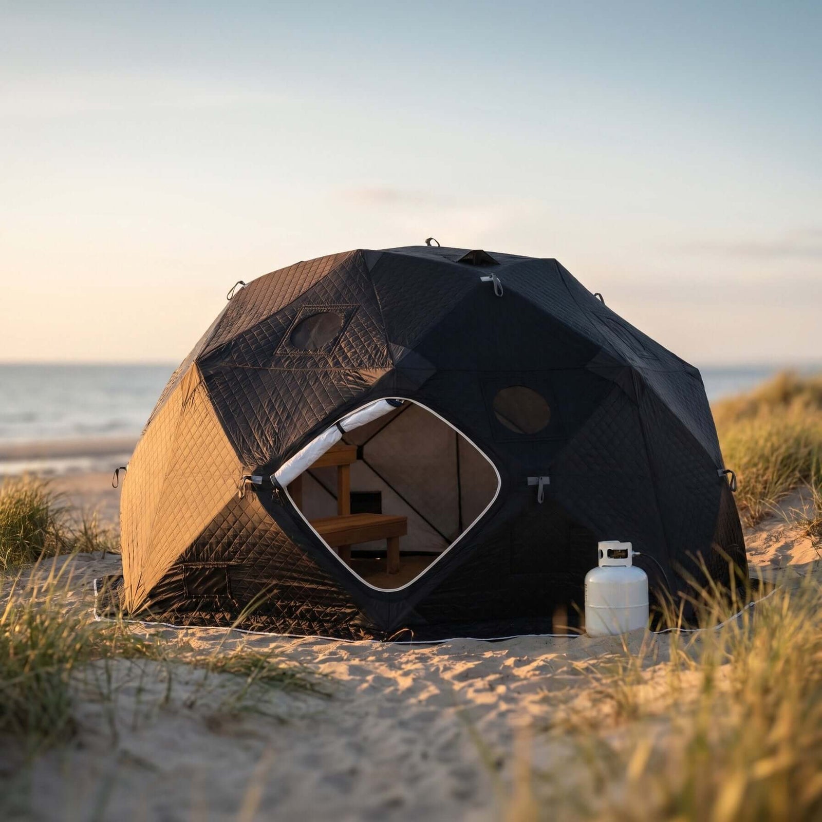 SaunaLife SaunaTrekker XL Portable Sauna Tent set up on a beach with a gas cylinder, ideal for up to 6 people.
