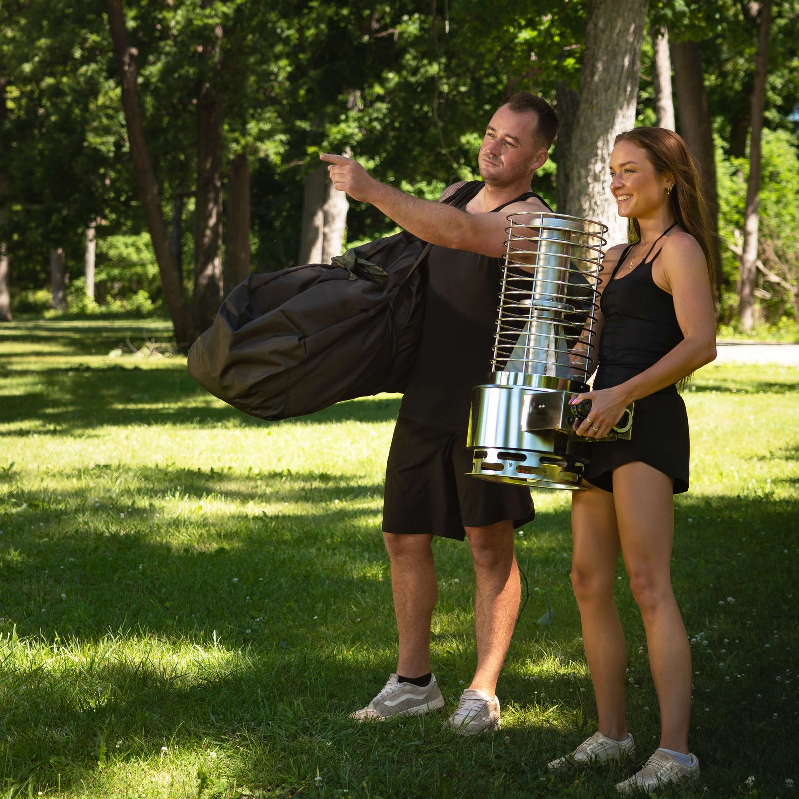 Two people preparing to set up the SaunaLife SaunaTrekker XL Portable Sauna Tent outdoors.