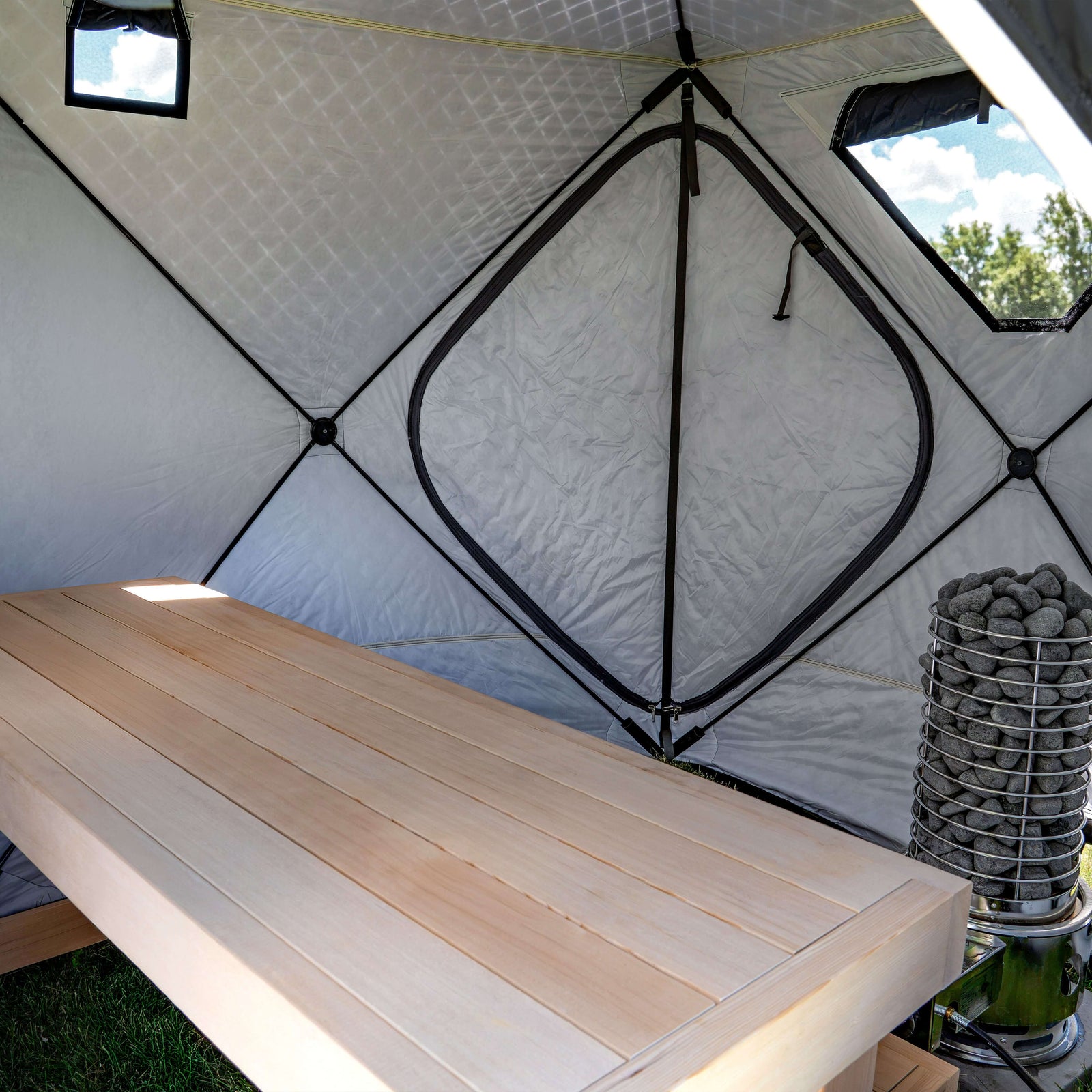 Interior view of SaunaLife SaunaTrekker Portable Sauna Tent with wooden bench and stone heater.