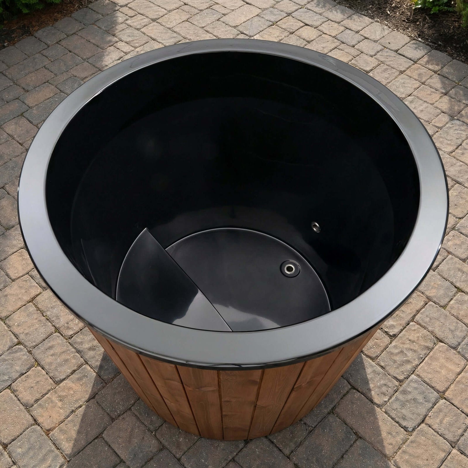 Outdoor wooden S1N plunge tub, by SaunaLife, on a paved surface