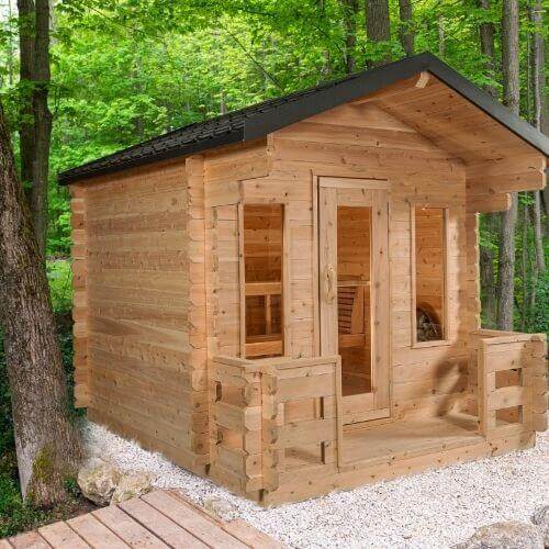 Dundalk Leisurecraft Georgian Cabin Sauna with Porch in a lush forest setting, made from sustainable white cedar wood. CTC88PW