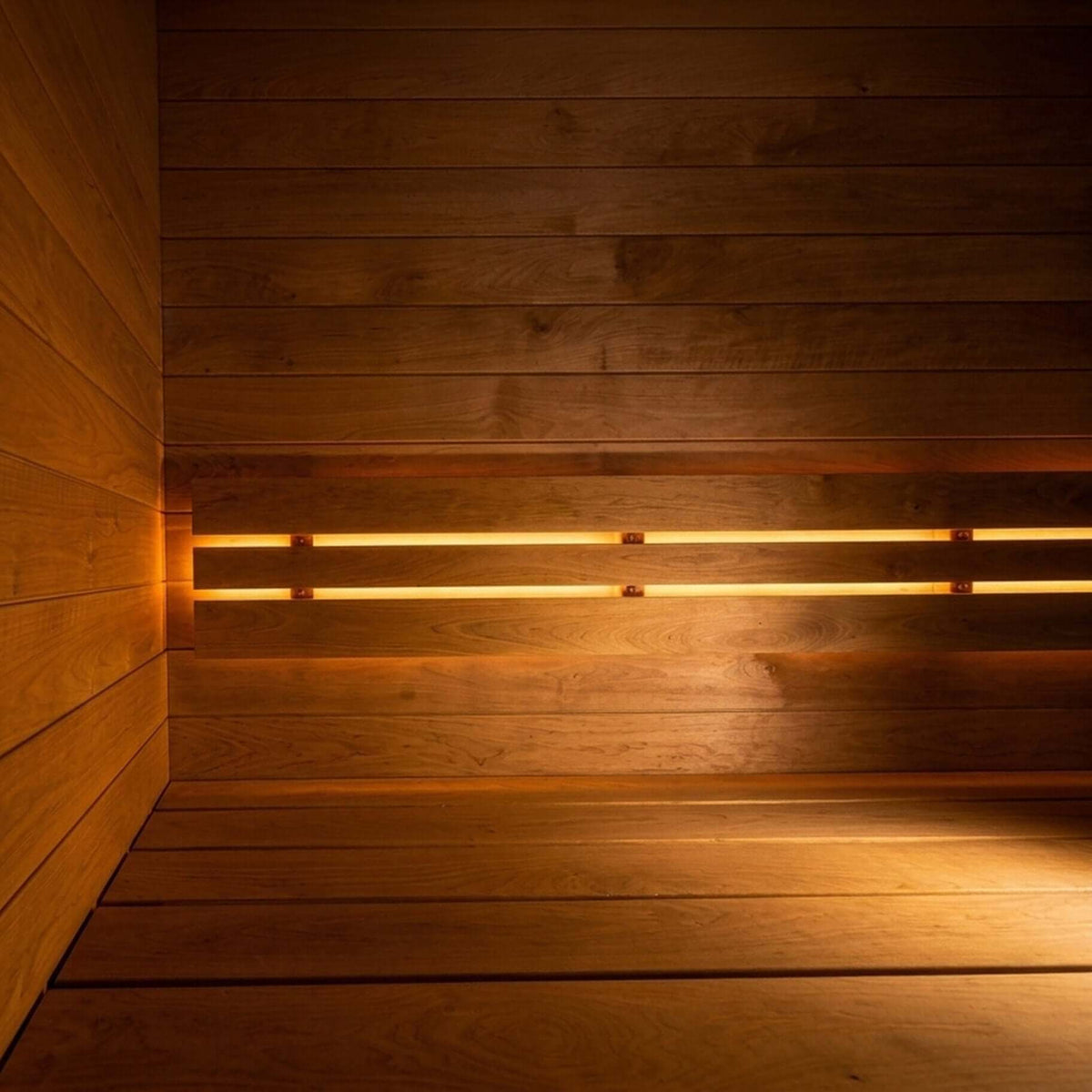 Warm wooden SaunaLife G6 sauna interior with plank walls and bench, lit by horizontal linear lights mounted behind the back bench.