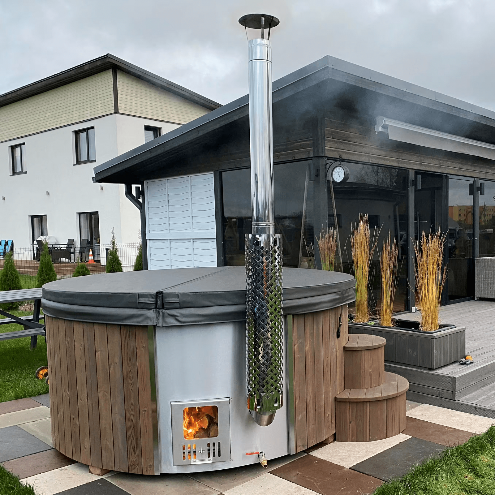 SaunaLife S4N outdoor hot tub with wood burning stove in a backyard setting