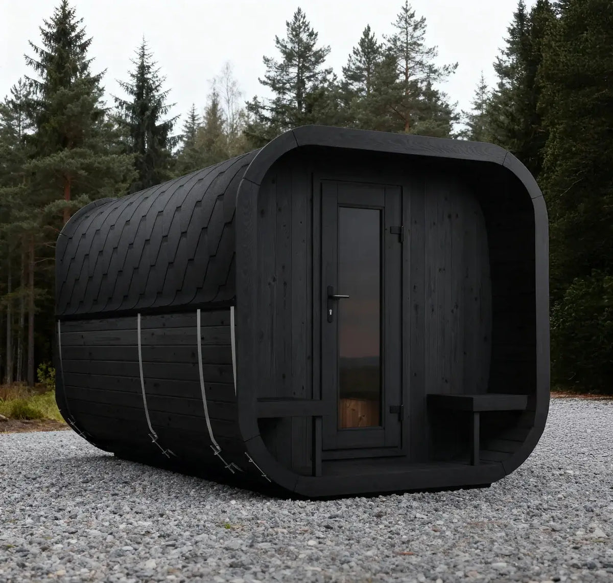 SaunaLife's CL12GCPB modern black wooden cabin with a rounded rectangular shape, a glass-paneled door, and a small bench on the exterior, set on a gravel surface with a forest background.
