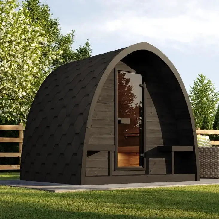Modern outdoor G3B sauna pod from SaunaLife, with wooden exterior and glass door, surrounded by greenery.