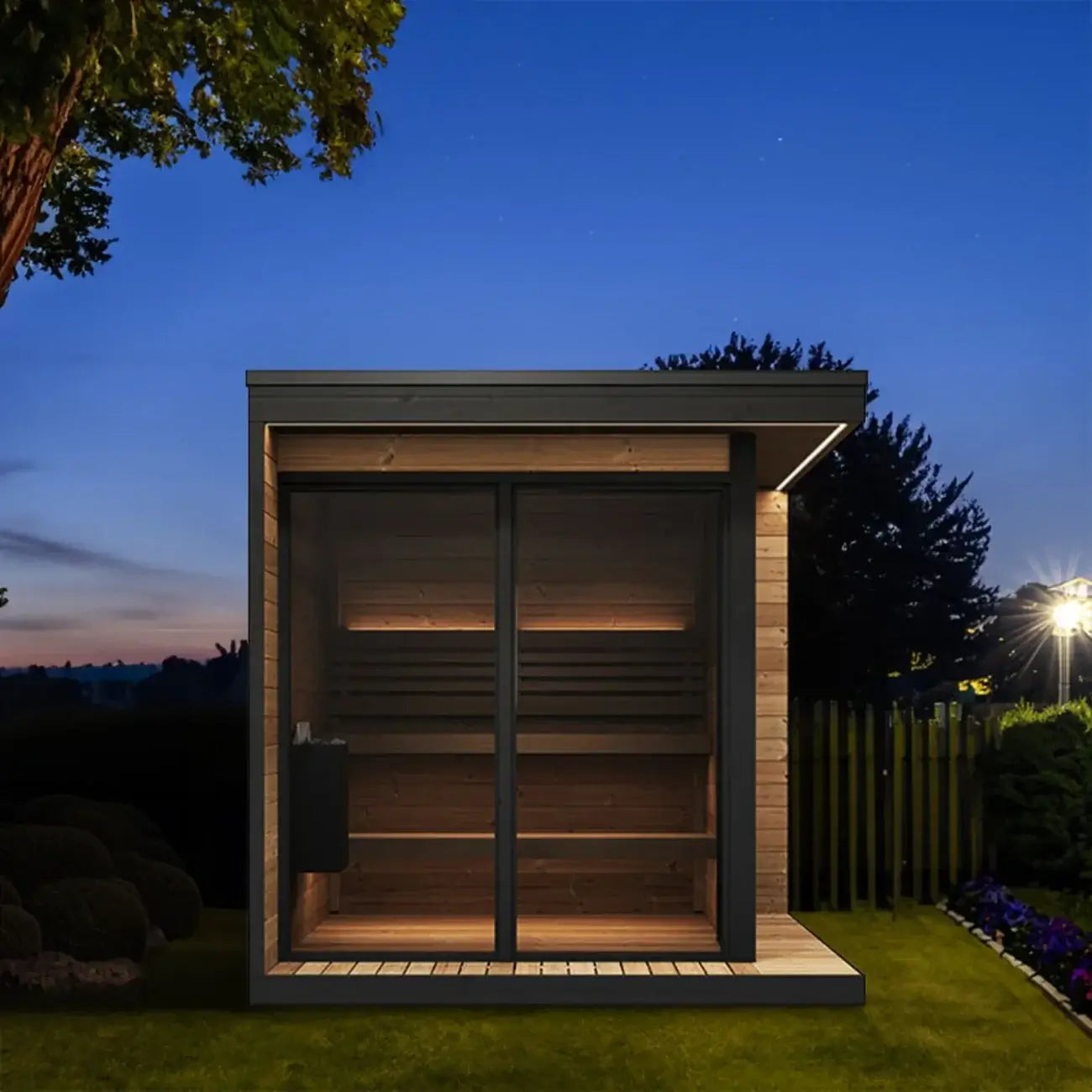 Modern GL6 outdoor sauna from SaunaLife, with wooden exterior, glass door and window at night.